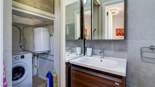 a bathroom with a sink and a washing machine at Stunning villa w Private pool TT table Sleeps 14 in St. Julianʼs