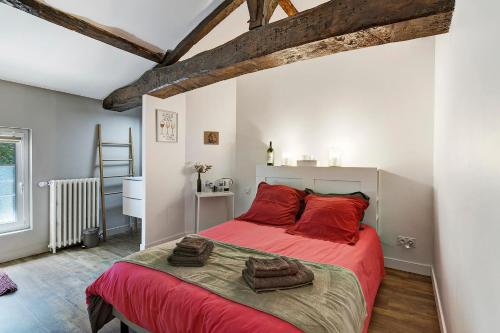 a bedroom with a red bed with red pillows at Chambres D'hôtes Chapetit in Saint-Denis-de-Pile