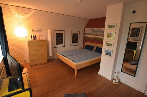 a bedroom with a bed and a tv in it at Alte Landjägerei Aukrug in Aukrug