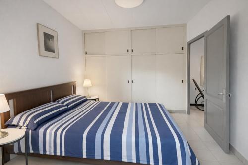 ein Schlafzimmer mit einem blau-weiß gestreiften Bett in der Unterkunft Ca La Roseta in Castellfollit de la Roca