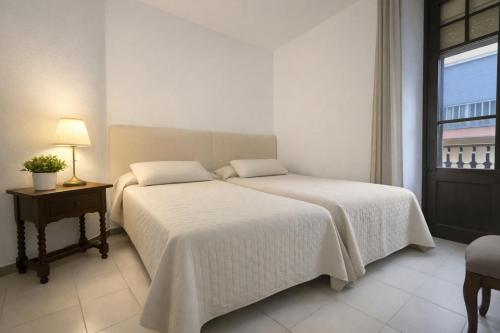 ein Schlafzimmer mit einem Bett, einem Tisch und einem Fenster in der Unterkunft Ca La Roseta in Castellfollit de la Roca