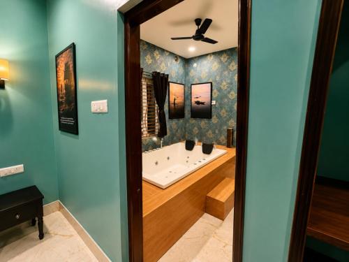 a bathroom with a bath tub with a ceiling fan at Arka by Utkalio in Puri