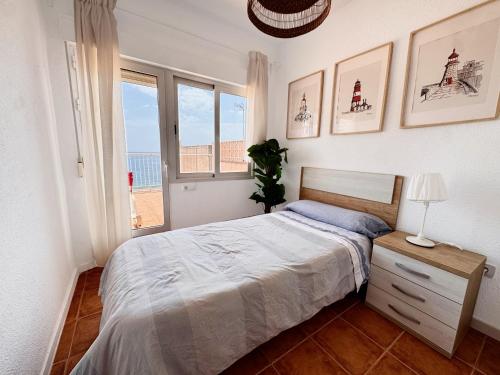 a bedroom with a large bed and a window at La Paloma, Chalet a pie de playa in Águilas
