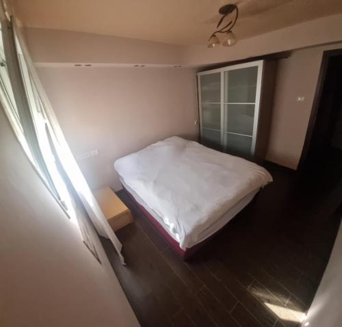 a small bedroom with a bed and a window at BlueStay in Qiryat Yam