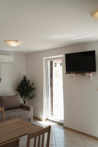a living room with a couch and a television on a wall at GARDEN in Nerezine