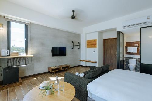 a bedroom with a bed and a couch and a table at Chillax Inn B&B 恆春鬆塊民宿 in Hengchun