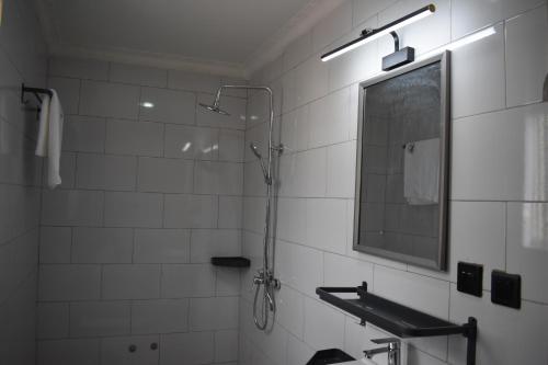 a bathroom with a shower and a mirror at COMFORT HOTEL Ltd in Gasanze