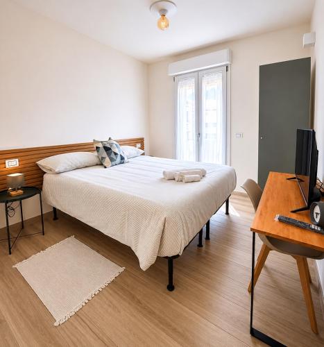 a bedroom with a bed with a television and a desk at Nàlua Sardinia Experience in Quartu SantʼElena