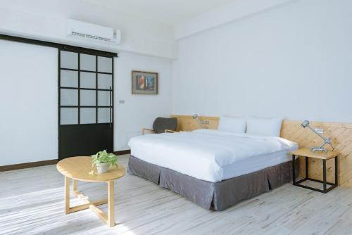a bedroom with a large bed and a table at Chillax Inn B&B 恆春鬆塊民宿 in Hengchun