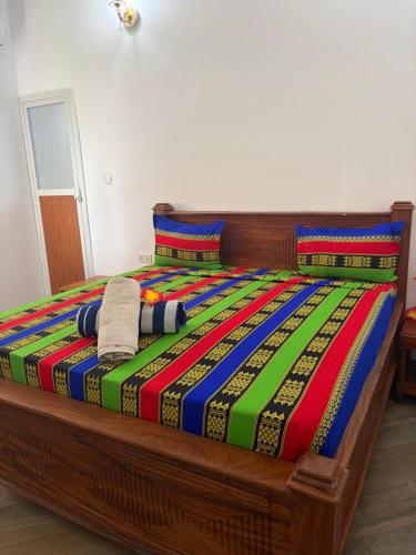 a bed with a colorful blanket and two pillows at La luna di zanzibar in Kiwengwa