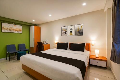 a bedroom with a large bed in a room at Townhouse Krishnagiri Formerly Vijay Inn in Krishnagiri