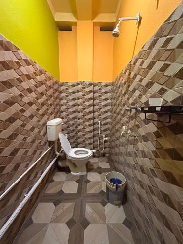 a bathroom with a white toilet in a room at Sundarban Residential Hotel in Pātharpratima Island