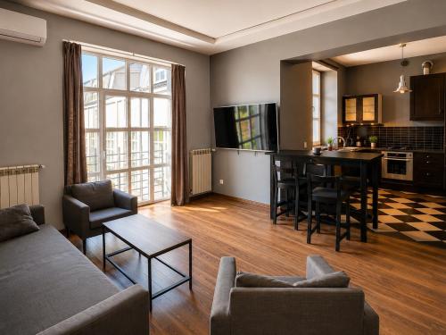 a living room with a couch and a table and a kitchen at INSEN Apartamenty Manufaktura Sauna i Masaże Apartament Superior in Łódź