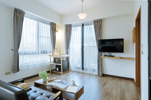 a living room with a couch and a tv at Chillax Inn B&B 恆春鬆塊民宿 in Hengchun
