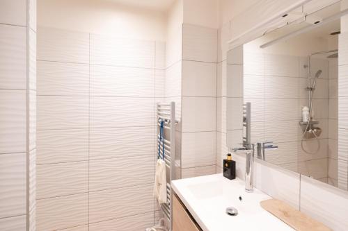 a white bathroom with a shower and a sink at Maison Cosy Bohème Chic Biarritz in Biarritz