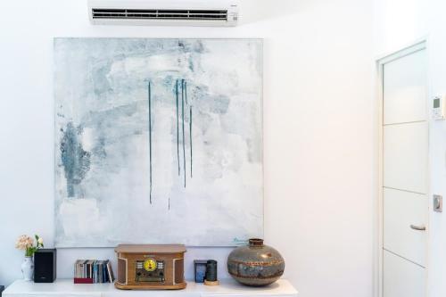 a white room with a clock and a painting on the wall at Chambre D'hôtes Villa Menta in Arbonne