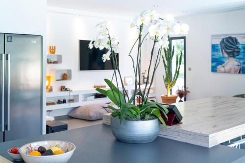 a vase with flowers on a table in a room at Chambre D'hôtes Villa Menta in Arbonne