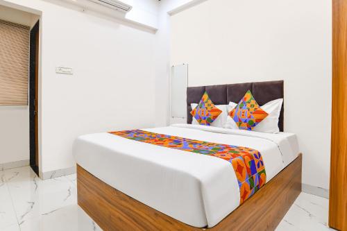 a white bedroom with a large bed in a room at Via Mannat in Indore