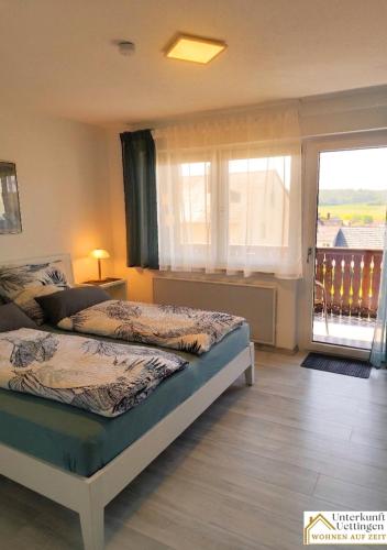 a bedroom with two beds and a balcony at Unterkunft-Uettingen in Uettingen