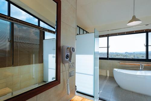 a bathroom with a tub and a sink and windows at Chillax Inn B&B 恆春鬆塊民宿 in Hengchun