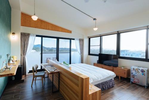 a bedroom with a large bed with a desk and a desk at Chillax Inn B&B in Hengchun