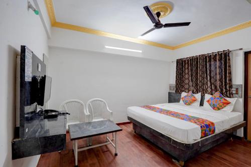 a bedroom with a bed and a ceiling fan at FabHotel Raj in Pune