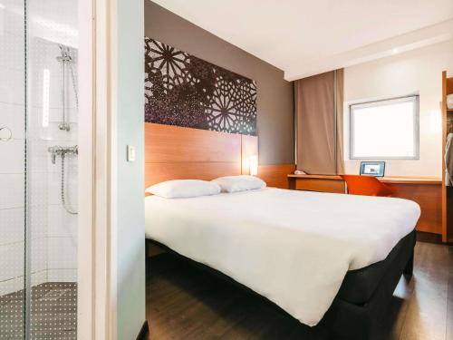 a hotel room with a large bed and a shower at Ibis Casanearshore in Casablanca