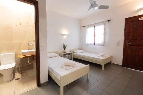 a room with a bathroom with a toilet and a sink at Alkyoni Forest Rooms in Skala