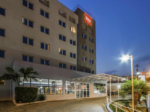 a hotel building with a lit up sign on it at ibis Jaboticabal in Jabuticabal