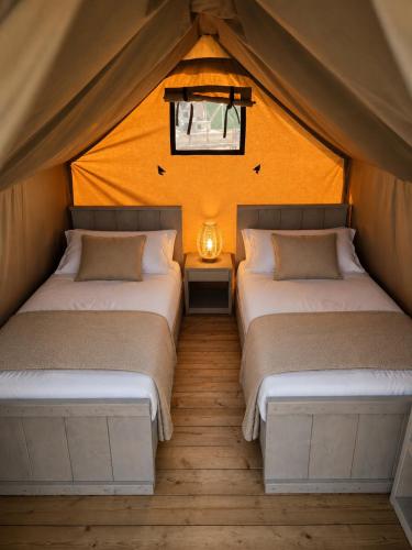 a bedroom with two beds in a tent at Camping Derby Loredo by Mola! in Loredo