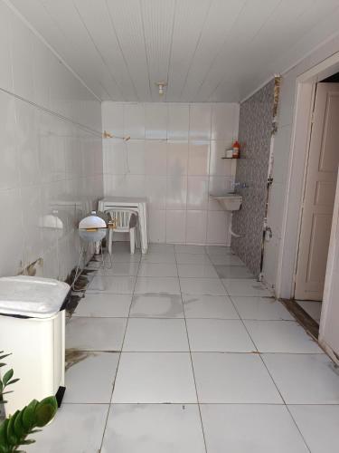 a room with a white tiled floor and a table at Casa ampla vila nova de colares in Serra