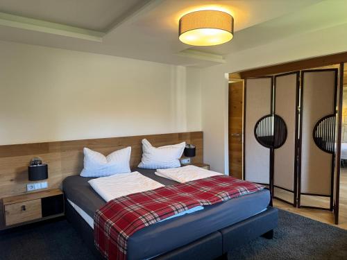 ein Schlafzimmer mit einem Bett und einer karierten Decke in der Unterkunft Gästehaus Apollo in Schwangau