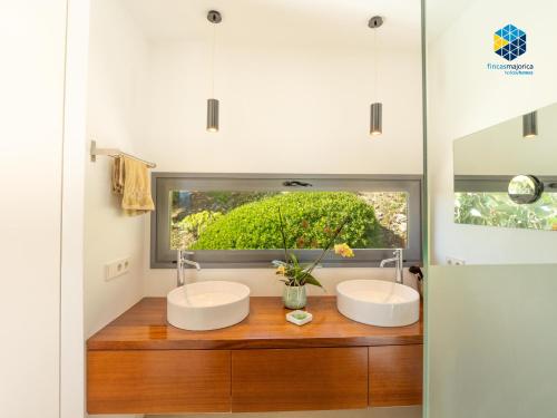 two sinks in a bathroom with a window at Villa Cata in Esporles