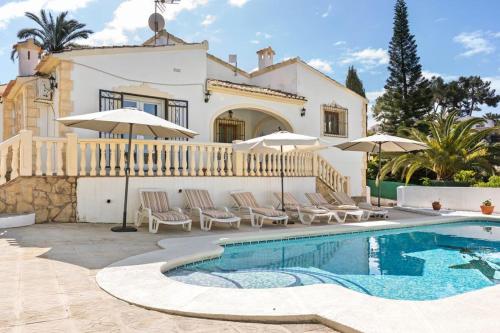 a villa with a swimming pool in front of a house at Villa Casa Para Ti in El Tosalet