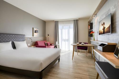 a hotel room with a bed and a desk at Citadines Arnulfpark Munich in Munich
