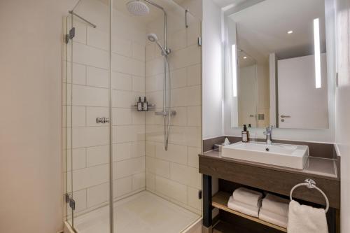 a bathroom with a sink and a shower at Citadines Arnulfpark Munich in Munich