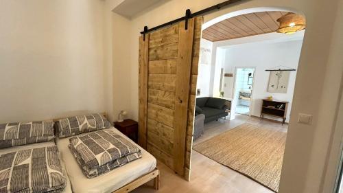 a bedroom with a bed and a large wooden door at Danube Atelier - The Garden in Rossatz