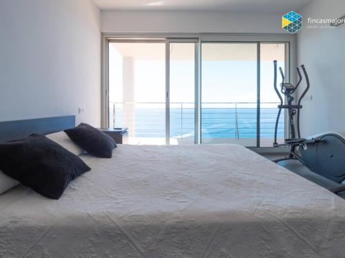 a bedroom with a large bed with a exercise bike at Villa Sa Troneta in Cala Pi