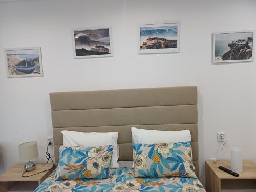 a bedroom with a bed and three pictures on the wall at Nazaré Holidays in Nazaré