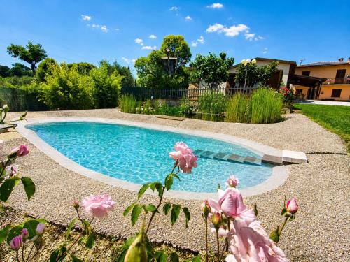 a swimming pool in a yard with pink flowers at Il Casale di Lucullo-Holiday Home with Pool and Spa- in Lucignano