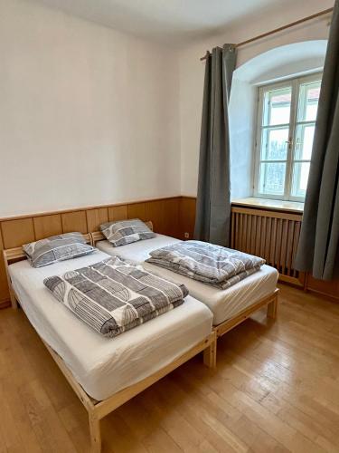 two beds in a room with a window at Danube Atelier - The Studio in Rossatz