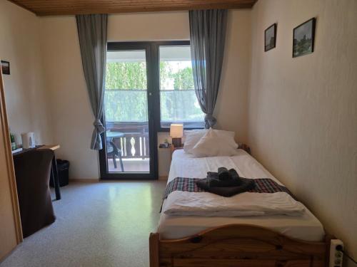a bedroom with a bed and a large window at Locvillare in Wadern