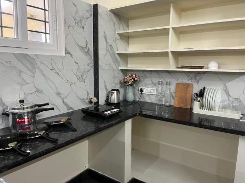 a kitchen with black and white marble counter tops at The Heritage Homes in Mysore