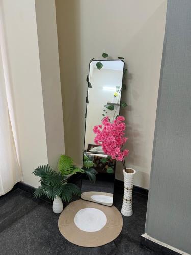 a bathroom with a mirror and two vases with flowers at The Heritage Homes in Mysore