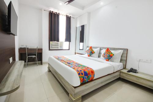 a bedroom with a large bed and a table at FabHotel Neu-Nest in Rishīkesh