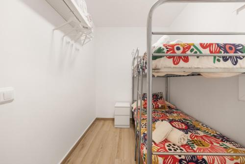 a bedroom with two bunk beds and a wooden floor at Apartament Platja L'arquitecte in L'Ampolla