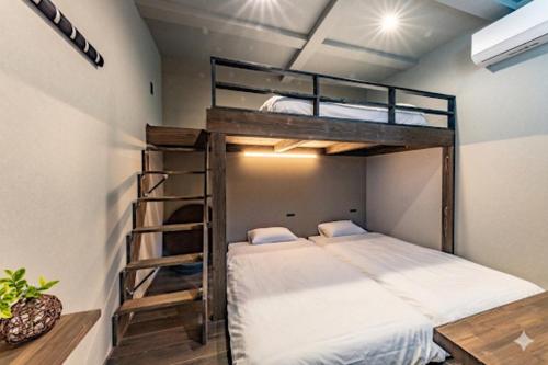 a bedroom with two bunk beds and a ladder at UG HOSTEL Takayama in Takayama
