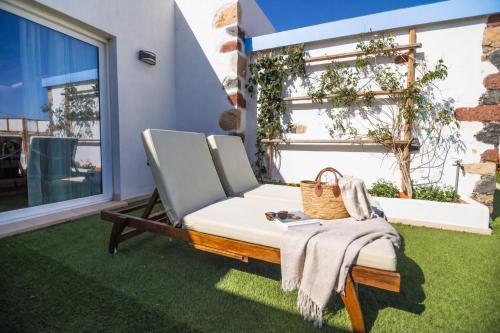 a chair sitting on a lawn next to a window at Hotel Boutique Rosario Martin in Puerto del Rosario
