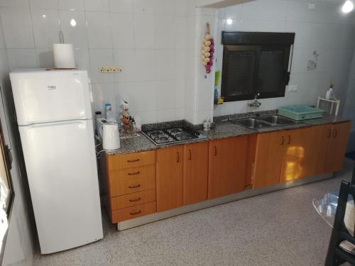 a kitchen with a white refrigerator and a sink at Rustic Chalet With Easy Golf Beach Access Oliva Nova in Oliva