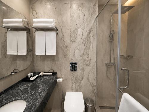 a bathroom with a toilet and a sink and a shower at Metropol Hotel Bishkek in Bishkek